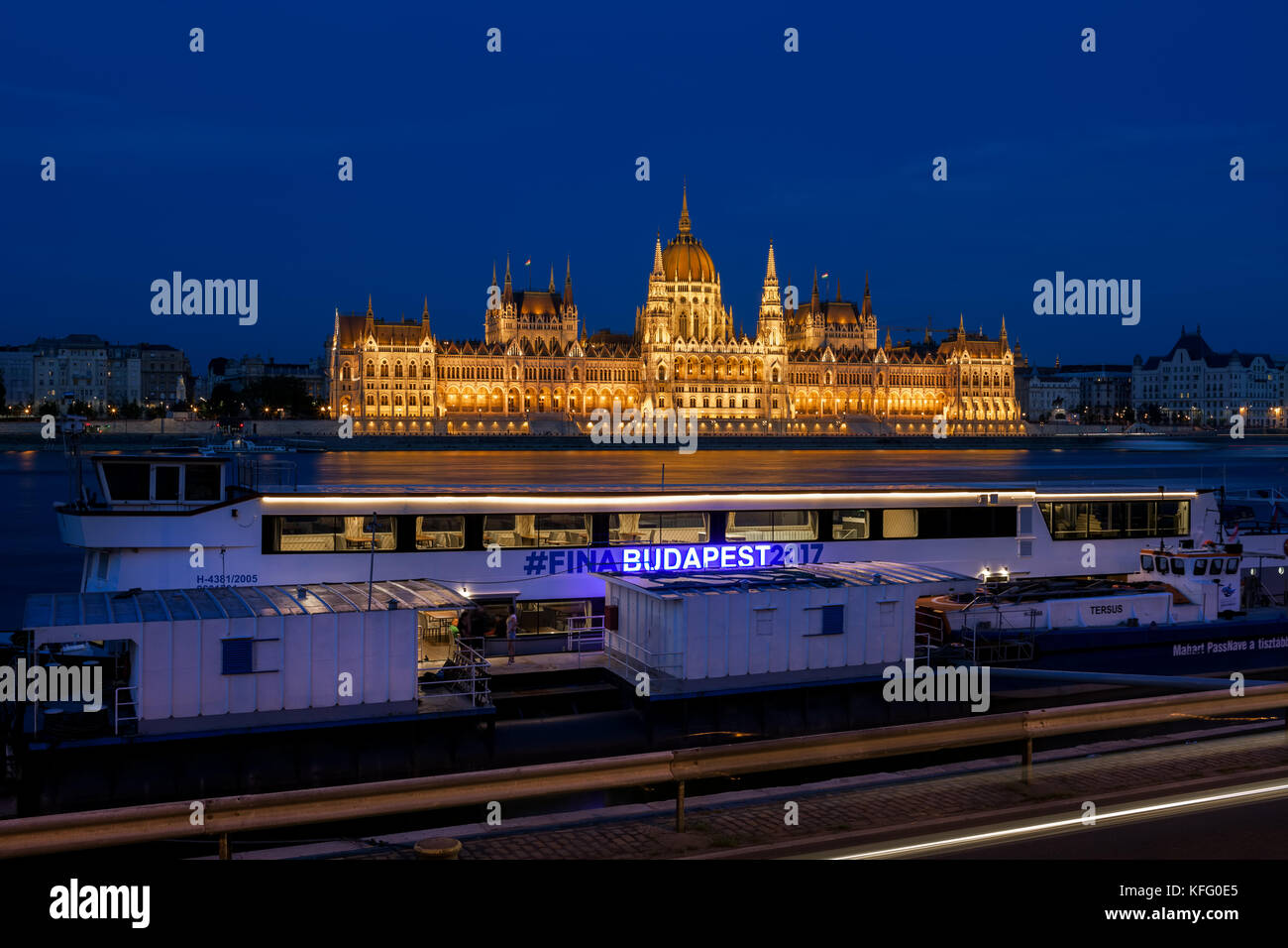 City of Budapest by night in Hungary, lighted Hungarian Parliament Building, boat ready for 17th FINA World Championships 2017 on Danube river Stock Photo
