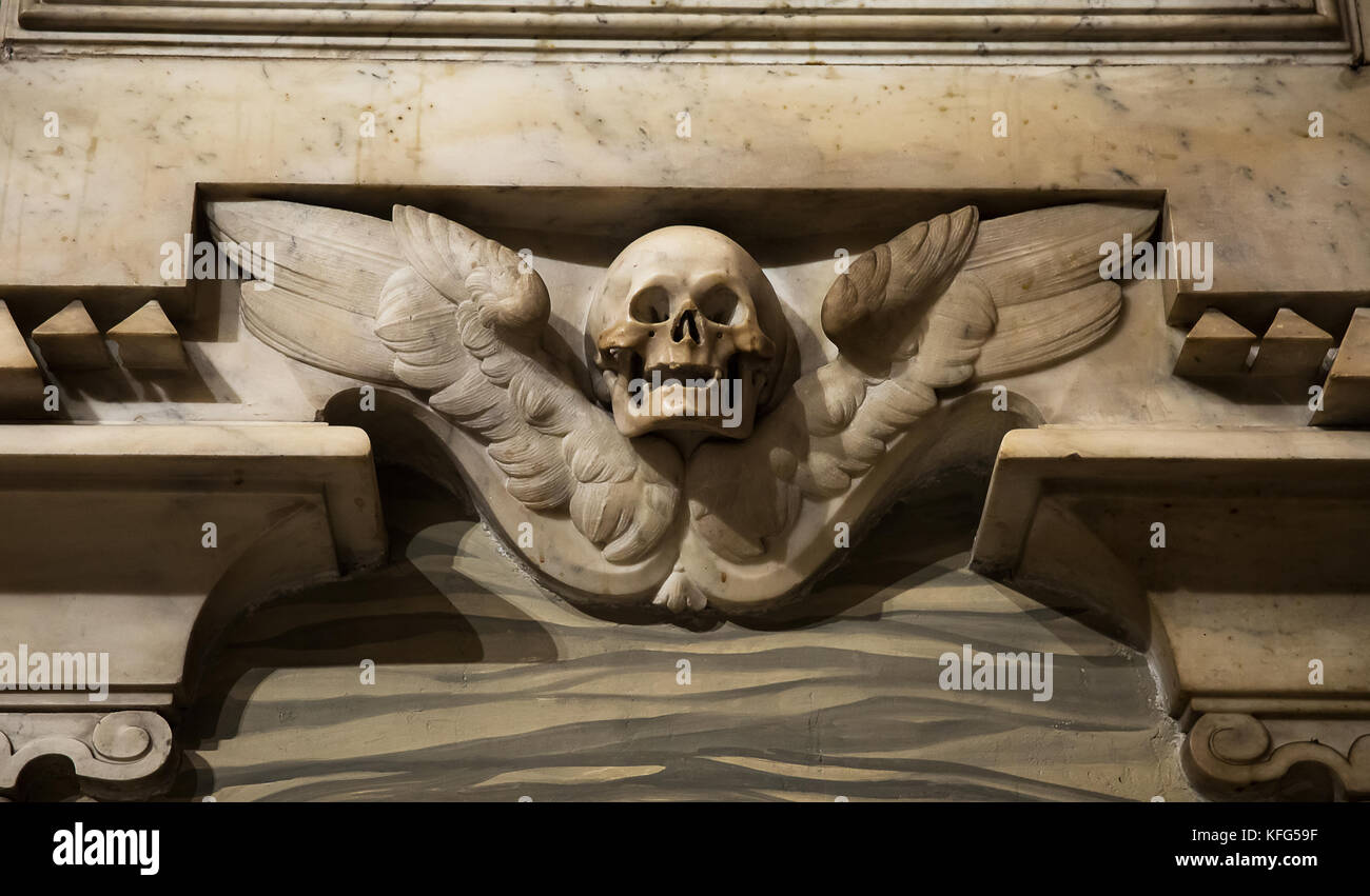 Marble skull and wings on the wall in the Catholic church in Rome, Italy. Stock Photo