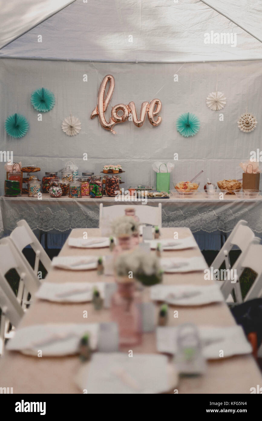 Long White Table Setting With White Chairs Lined Up