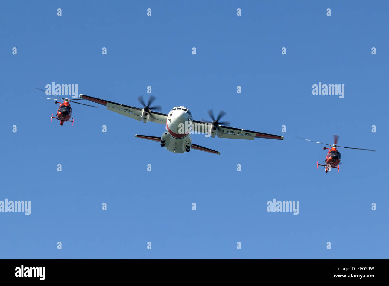 A pair of Coast Guard MH-65 Dolphin helicopters from Air Station San Francisco fly in close formation with a C-27J Spartan from Air Station Sacramento Stock Photo