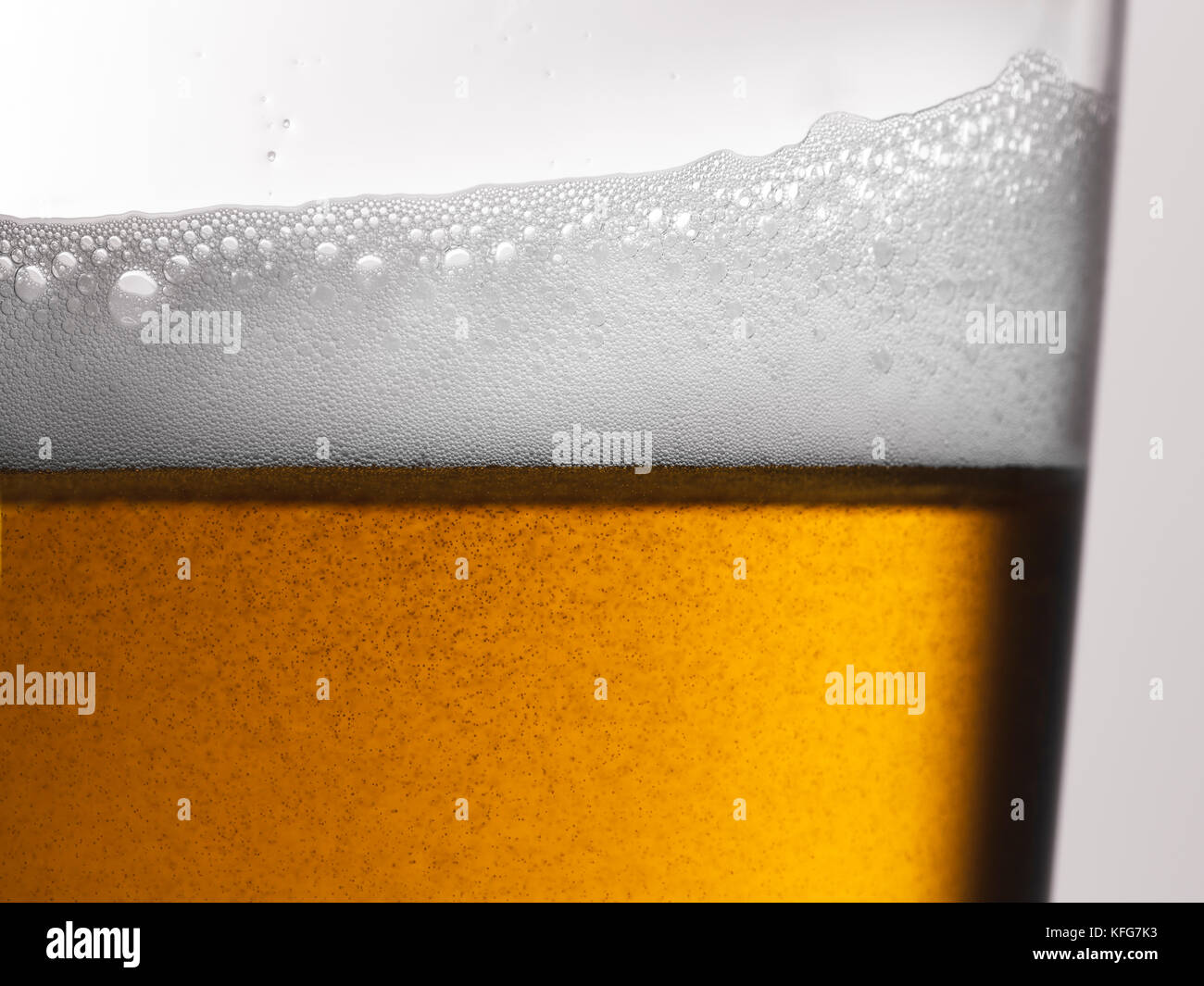 Freshly poured amber gold beer with frothy head and bubbles in a glass Stock Photo