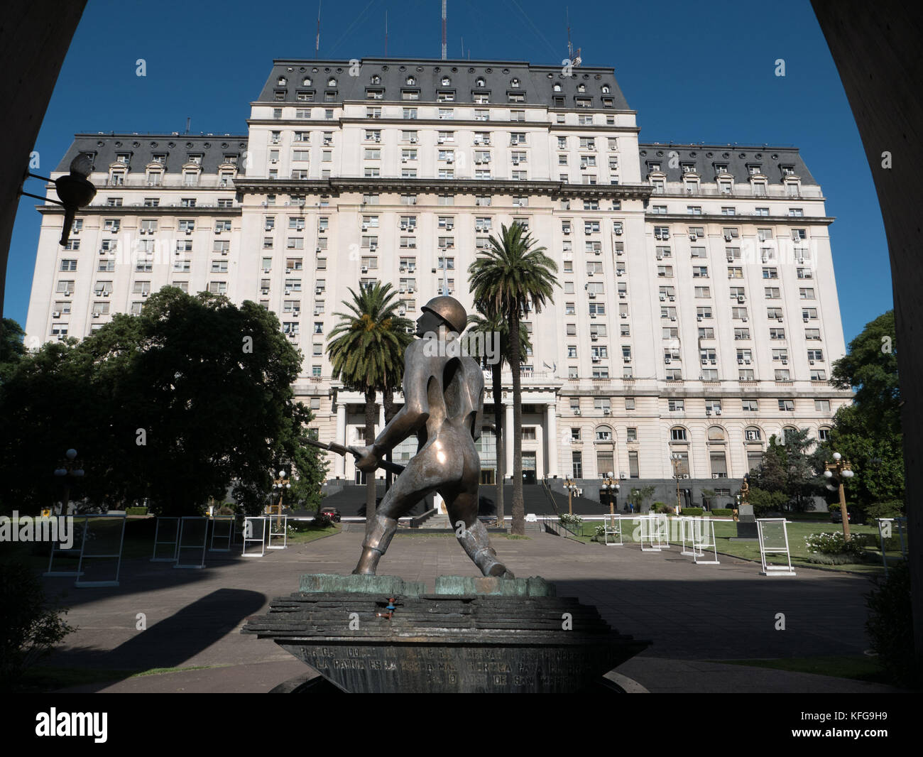 Bronze statue of soldier carrying rifle in front of Ministry of Defense building in Bueno Aires Argentina.  Imposing white stone building blue sky. Stock Photo