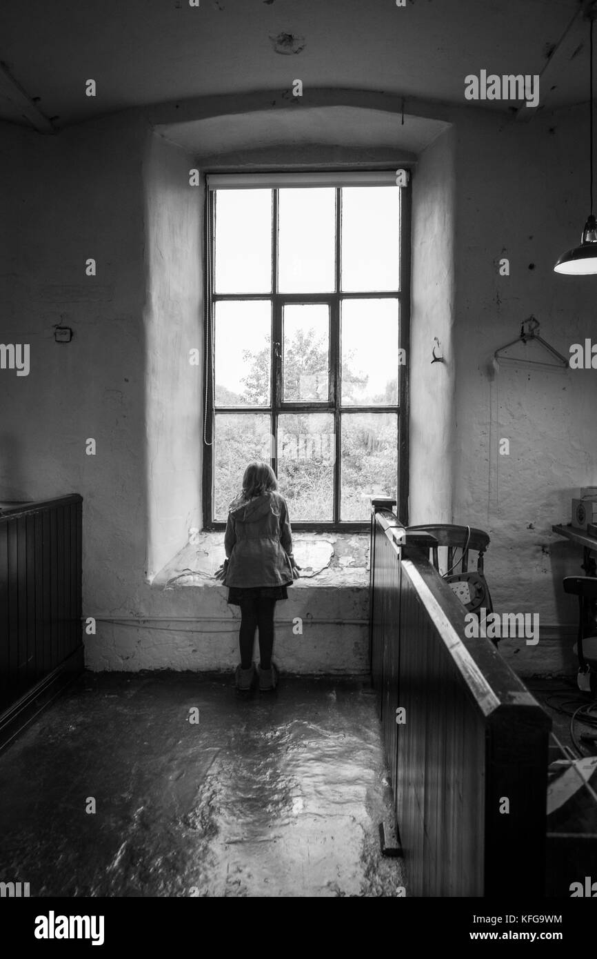 Child looking out of the window at Leeds Industrial Museum, Armley Mills, West Yorkshire. Stock Photo