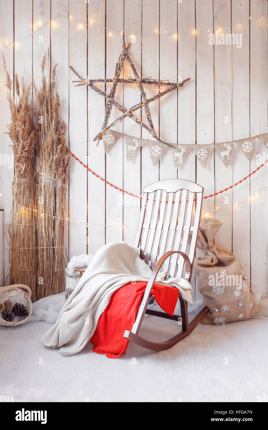 Christmas morning. Rocking chair with decorations by firewood and ...
