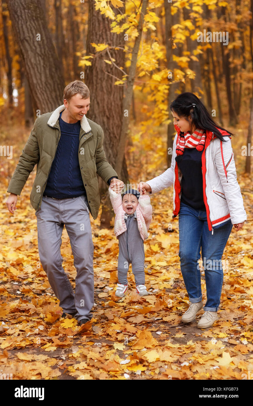 parents walk and play with little daughter Stock Photo