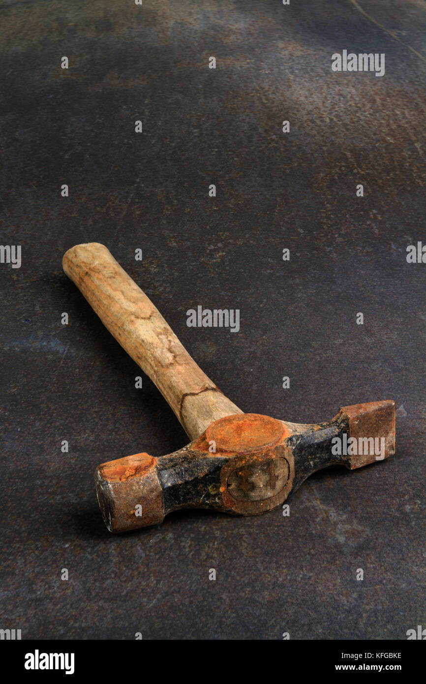 Rusty old hammer on a rusty metal background Stock Photo
