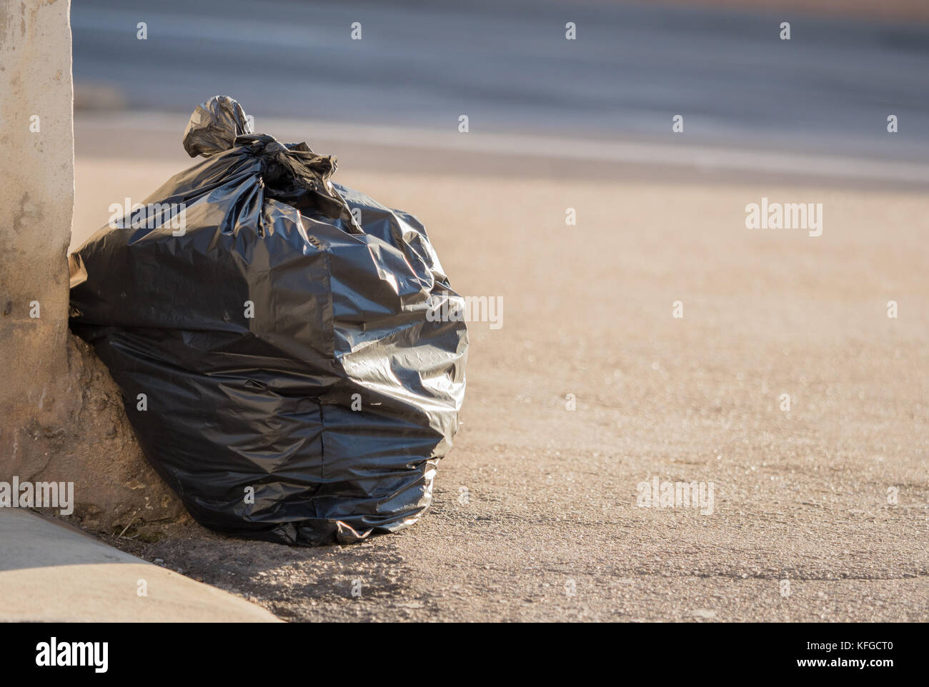 Black garbage bag lies on the road Stock Photo Alamy