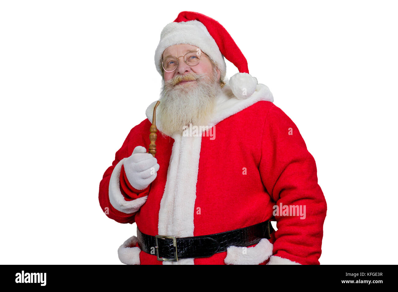 Portrait of Santa Claus with pipe. Bearded Santa Claus holding smoking pipe and looking upwards on white background. Realistic Santa Claus, studio sho Stock Photo