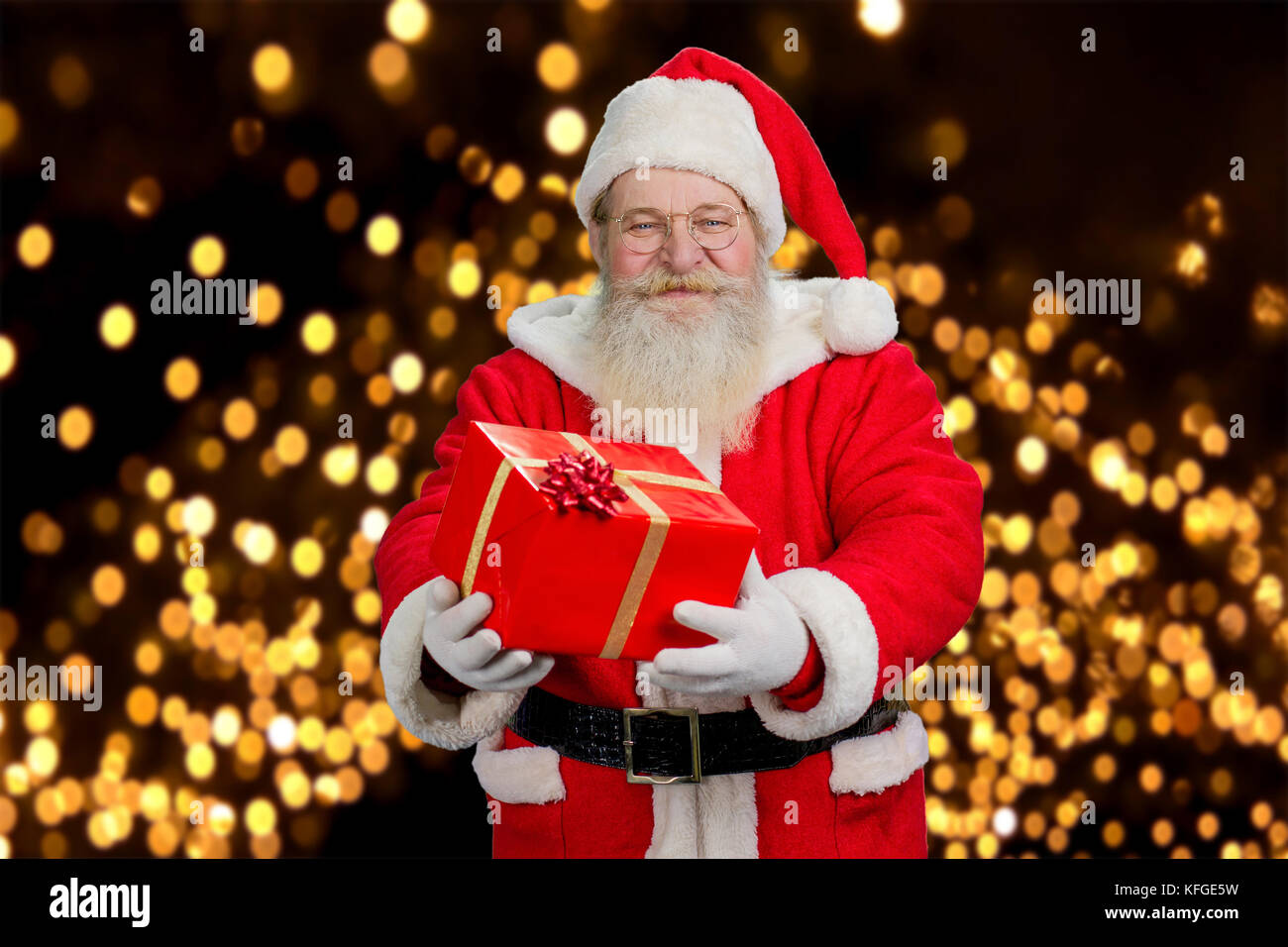Santa Claus offering beautiful gift box. Smiling old Santa Claus