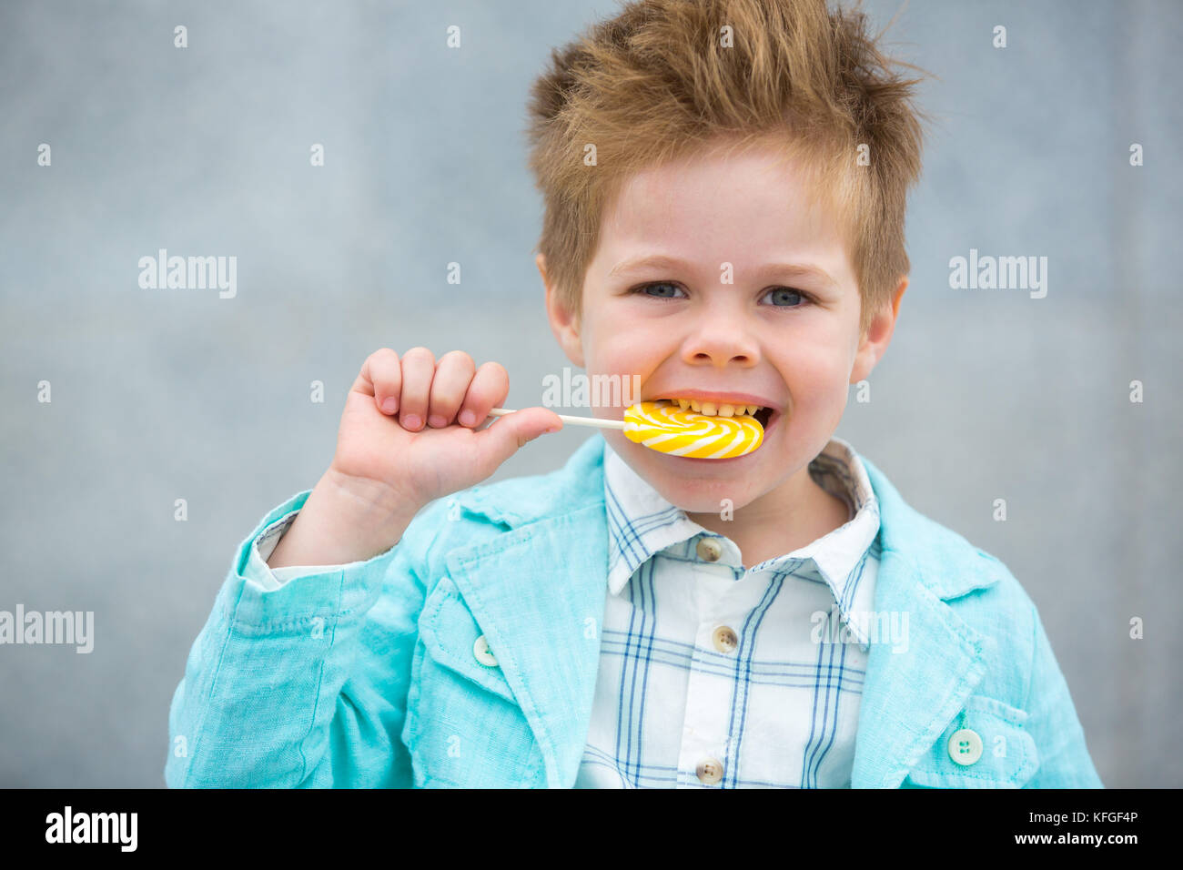 Fashion kid with lollipop near gray wall Stock Photo