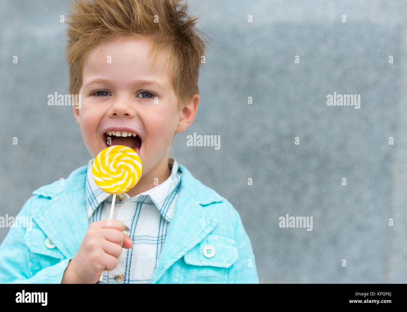 Fashion kid with lollipop near gray wall Stock Photo