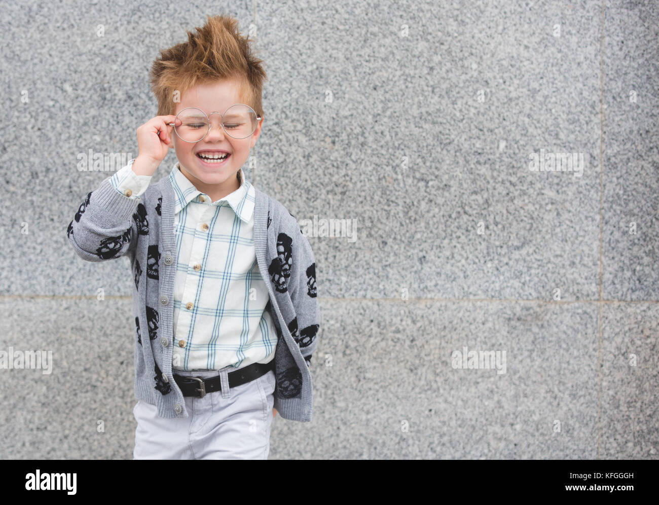Fashion kid with glasses near gray wall Stock Photo