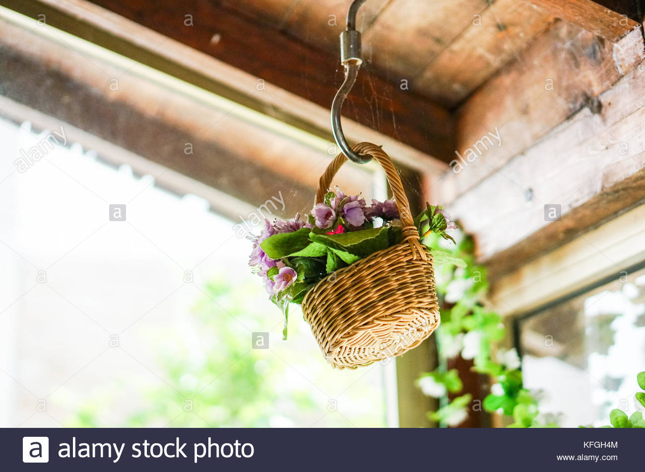 Fake Flowers In A Basket Hanging On A Dusty Ceiling Stock Photo