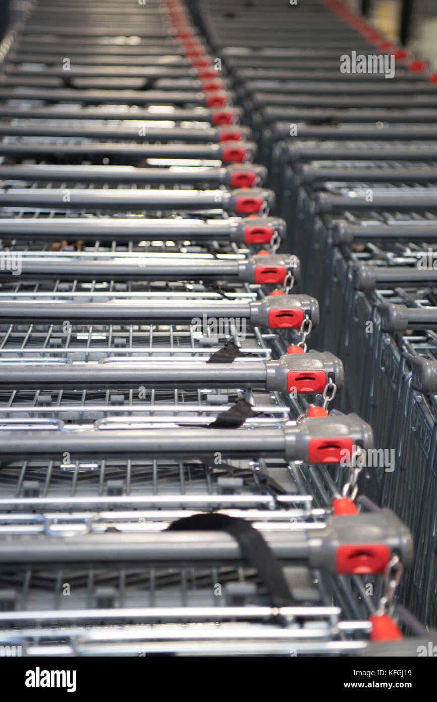 Coin operated supermarket shopping trolleys in a supermarket shop Stock ...