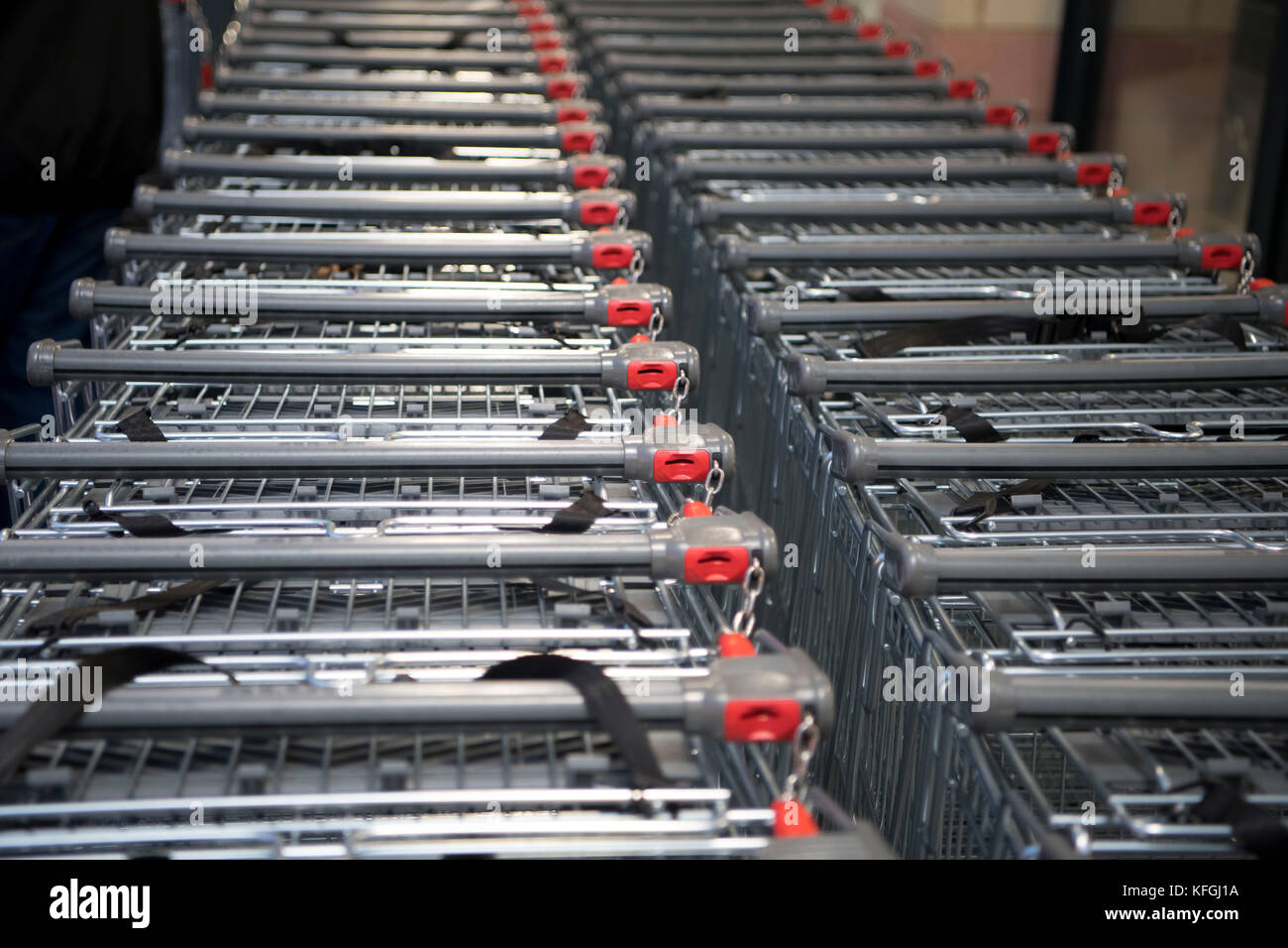 Coin operated supermarket shopping trolleys in a supermarket shop Stock