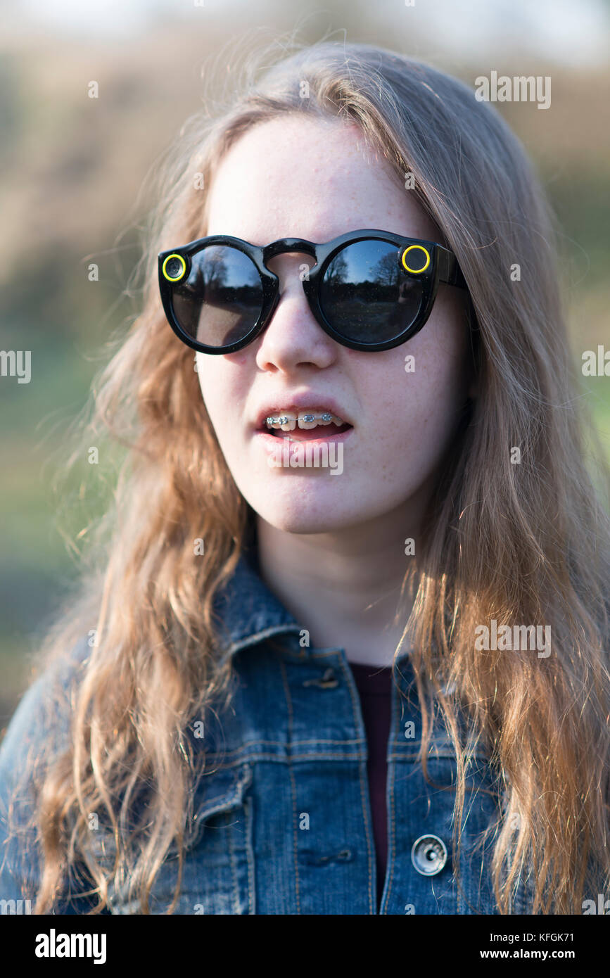 Teenage girl dressed in denim in outdoors sunshine wearing snapchat glasses  (sunglasses Stock Photo - Alamy