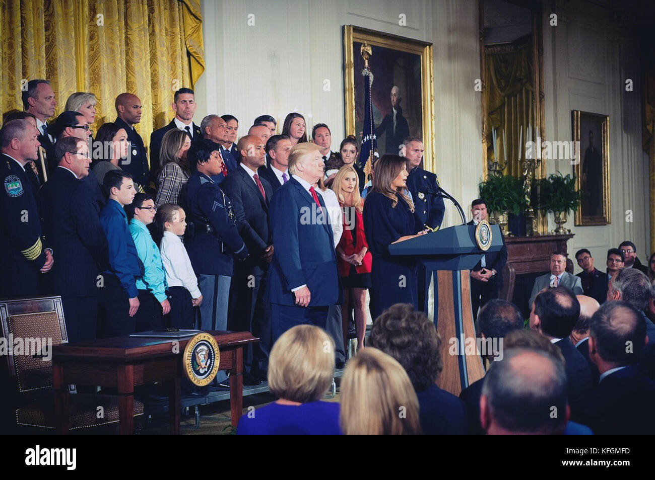 U.S First Lady Melania Trump addresses the audience as President Donald Trump looks on during an event declaring the opioid crisis a national public health emergency in the East Room of the White House October 26, 2017 in Washington, DC. Stock Photo