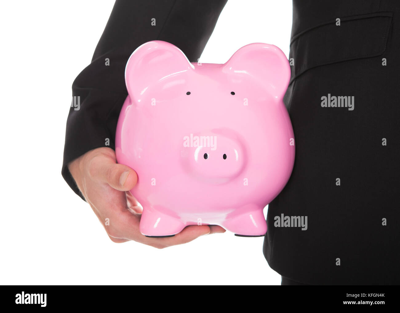 Closeup of businessman in a suit standing holding a pink ceramic piggy ...