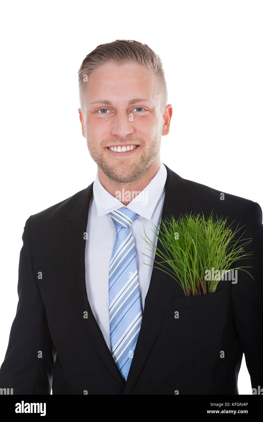 Smiling businessman with a fresh green plant in his pocket in place of a folded handkerchief in a conceptual image  isolated on white Stock Photo