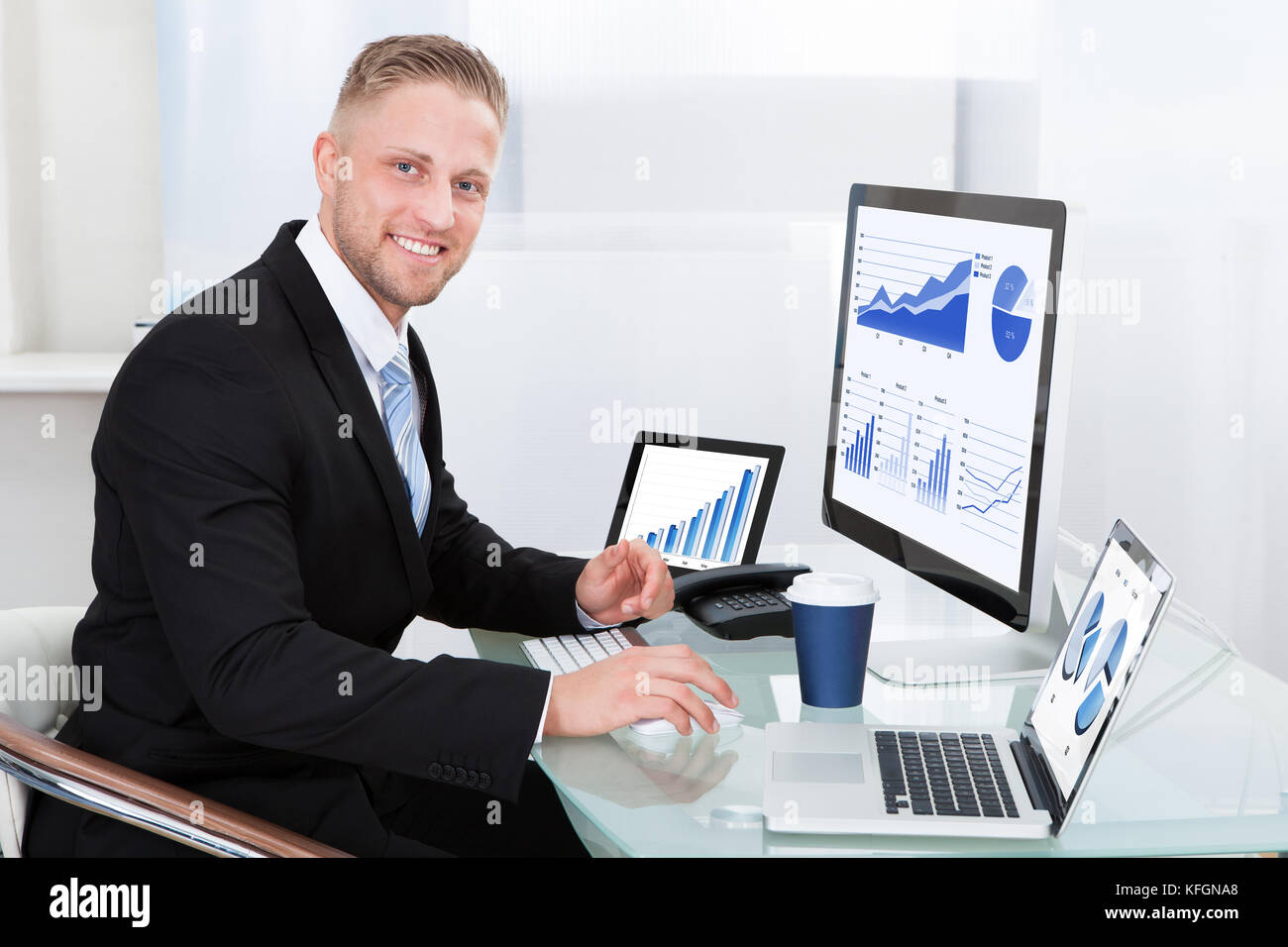 Businessman with good performance graph sitting at his desk with ...