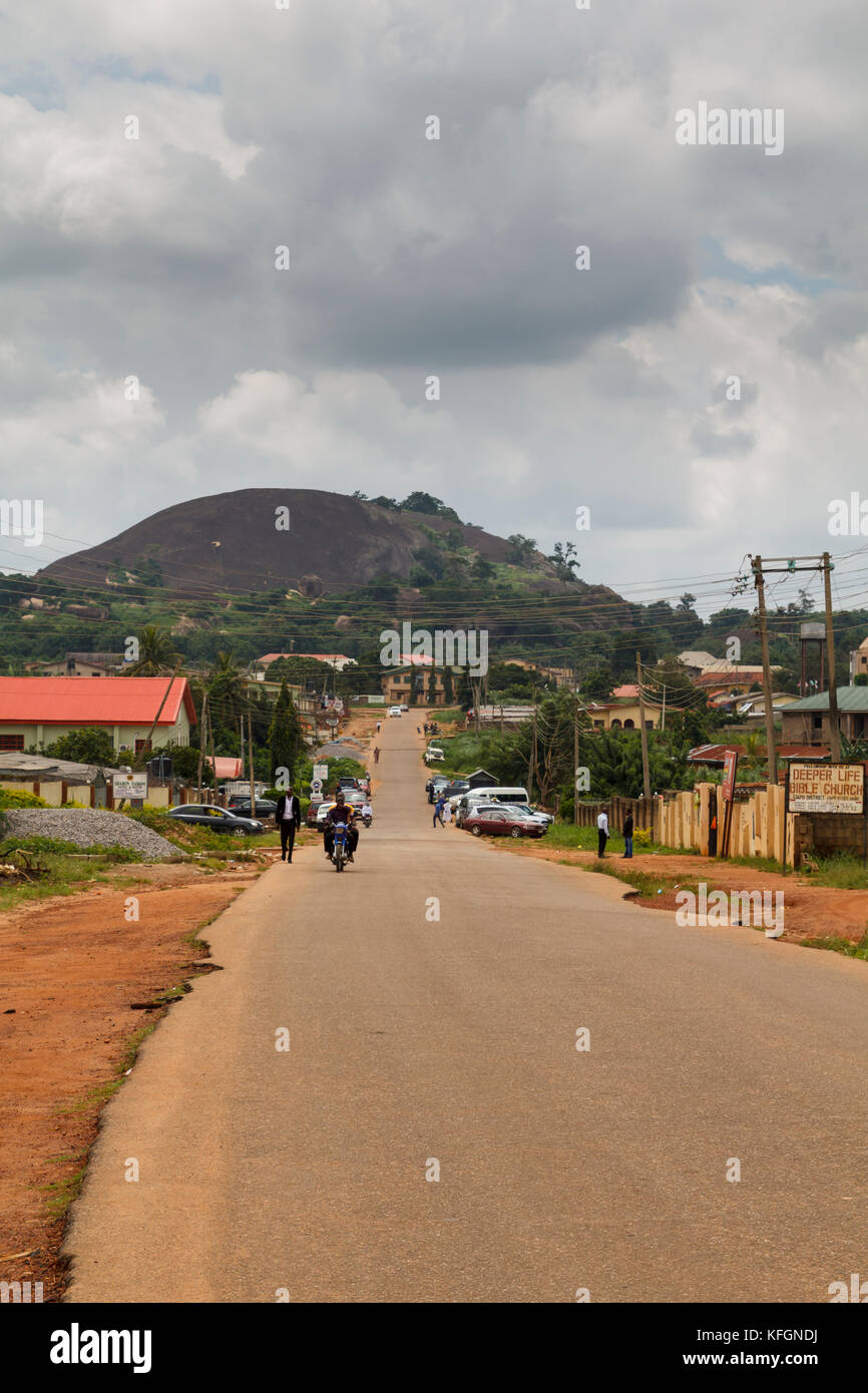 ARoad crossing the city of Akure, the largest city in Ondo State, Nigeria, with a granite mountain in the background Stock Photo