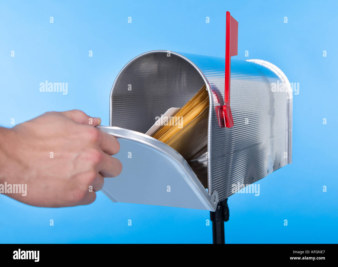 Man opening his mailbox to remove mail inside close up of his hand on