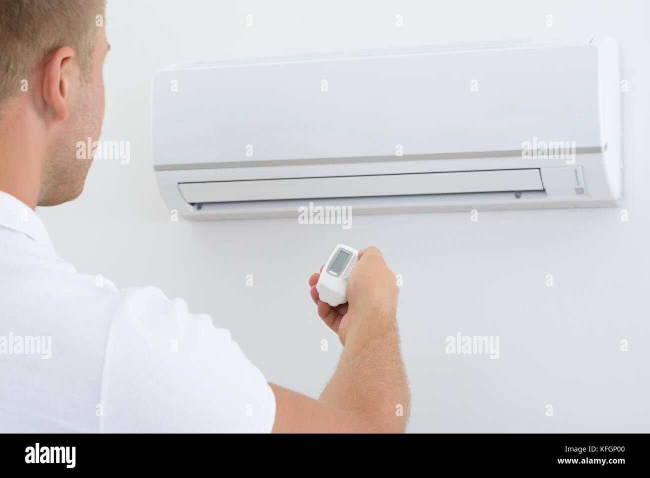 Man Operating Air Conditioner With Remote Controller Stock Photo - Alamy