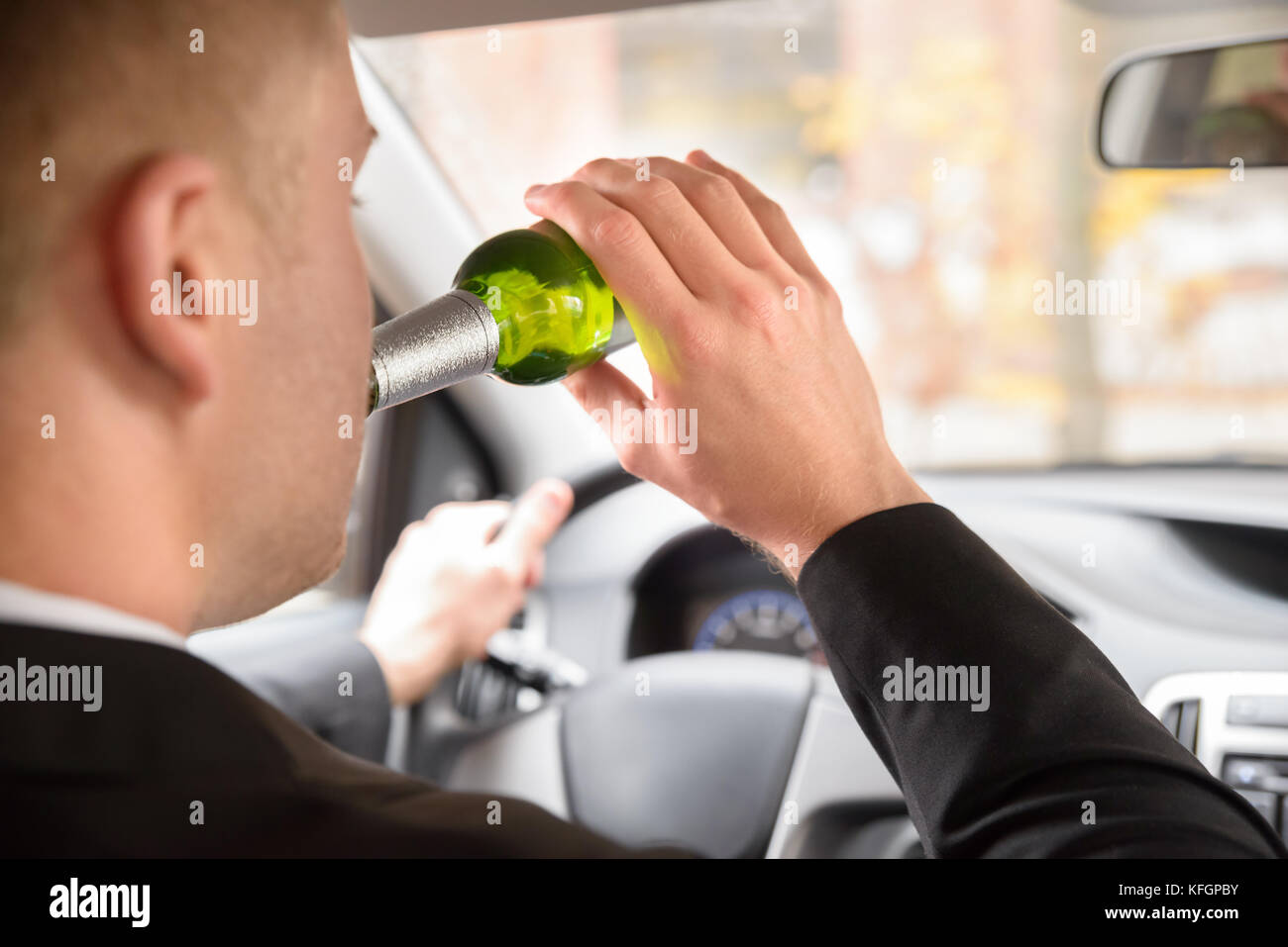 Close-up Of Man Drinking Beer While Driving Car Stock Photo