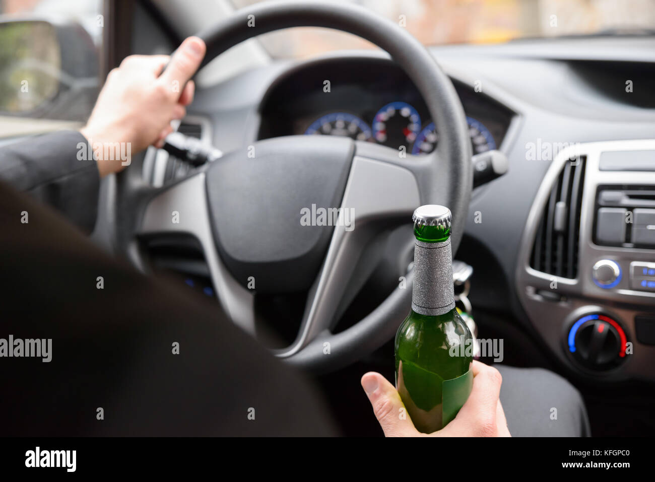 Close-up Of Man Holding Beer Bottle While Driving Car Stock Photo