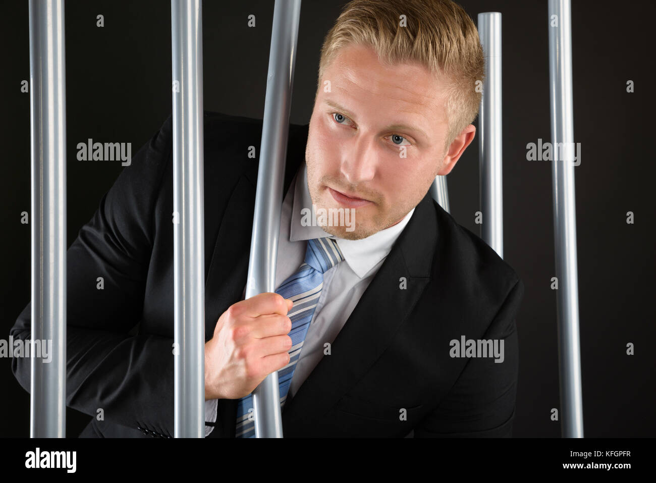 Portrait Of Young Adult Businessman Escaping From Prison Stock Photo