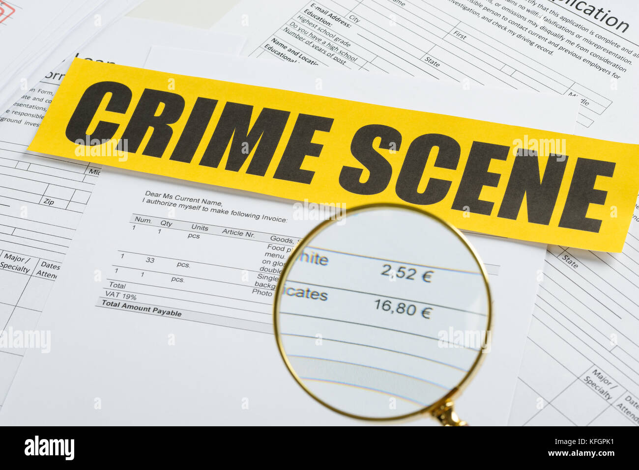 Close-up Of Magnifying Glass Over Documents With Crime Scene Yellow Tape Stock Photo