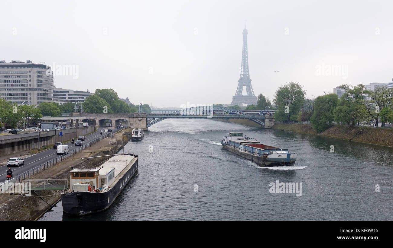 Paris; France-May 05; 2017: View of the Grenelle Bridge. On the embankment are moving cars and pedestrians, along the river-ship Stock Photo