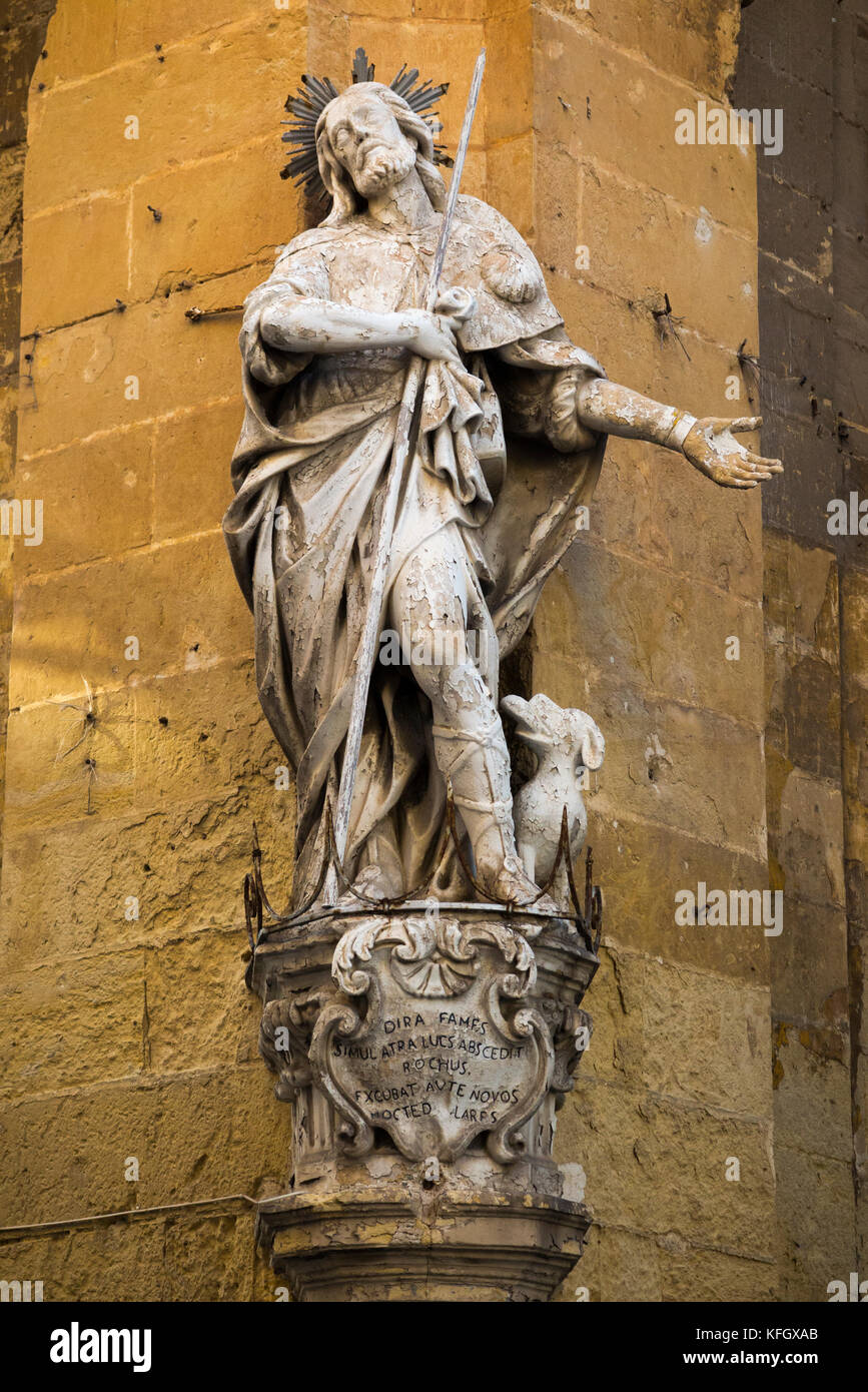 Religious Statue of a Saint / St Roque (on the corner of St Christopher Street and St Ursula Street ) corner of a building in Valletta, Malta. Stock Photo