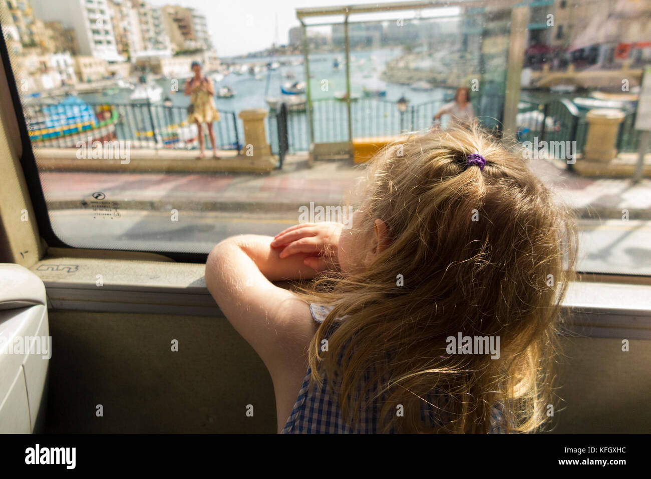 Three year old girl / child / passenger / passengers travelling on a public bus / using public transport in St Julians Bay / St Julian's Bay Malta. Stock Photo