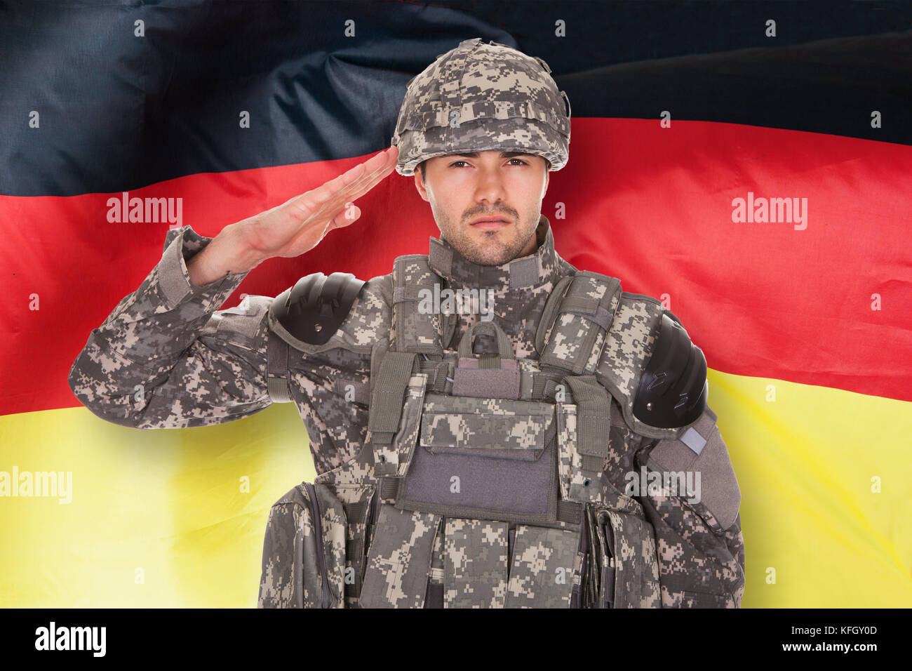 Portrait Of Soldier Saluting In Front Of German Flag Stock Photo