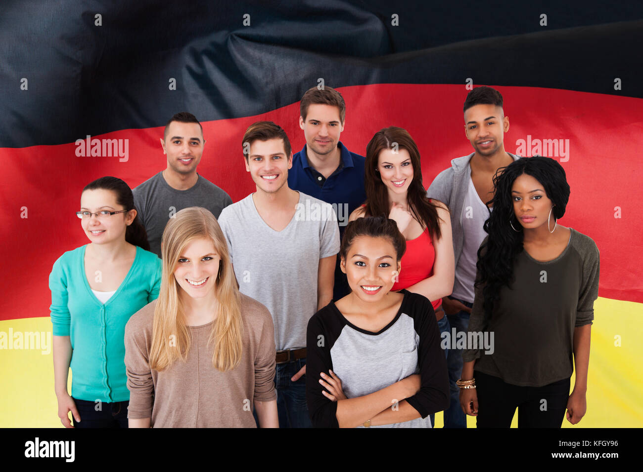 Happy Multi-ethnic Group Of People Standing In Front Of German Flag Stock Photo