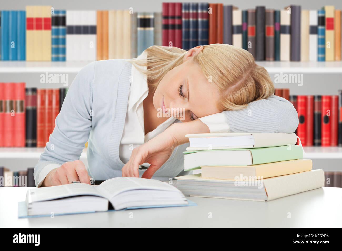 Tired Female Student Sleeping On The Books In The Library Stock Photo ...