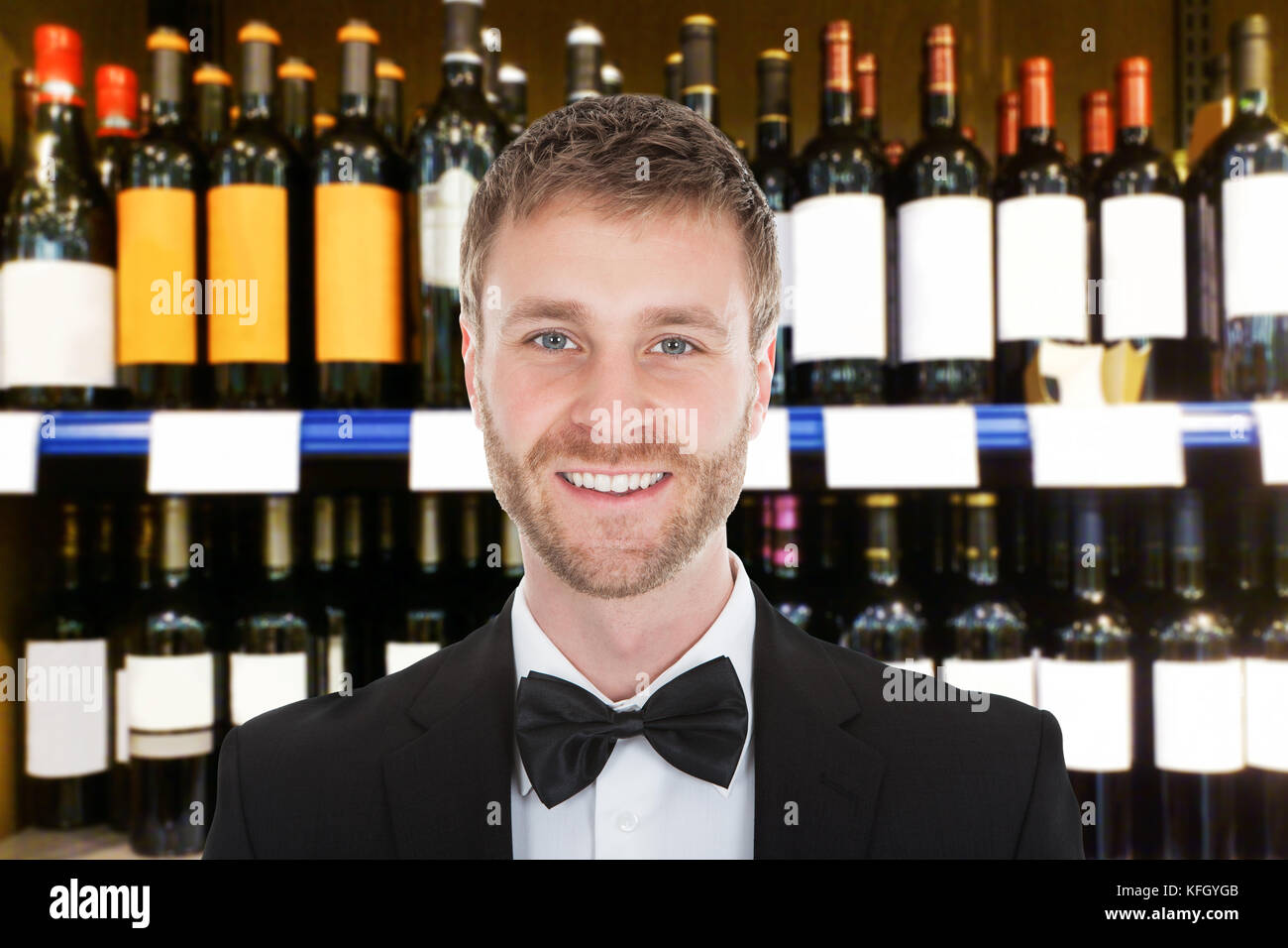Portrait Of Smiling Male Bartender In Front Of Wine Shelves Stock Photo