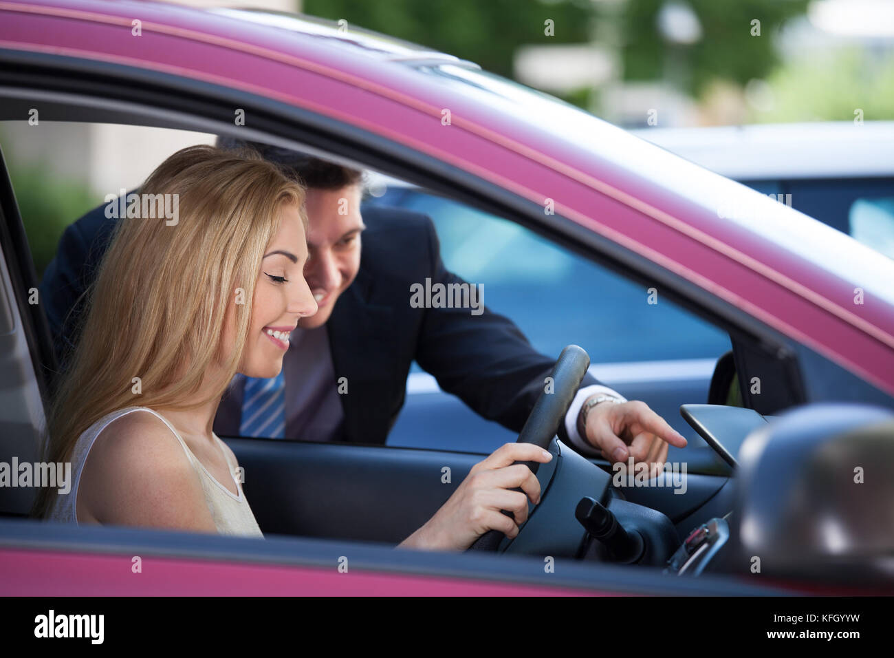 Salesman showing new car to female customer Stock Photo