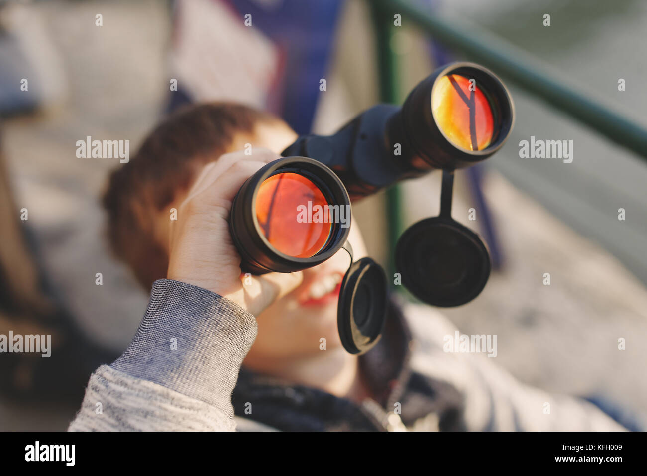 Little caucasian boy watching airplane on sky by binoculars, depth of field Stock Photo
