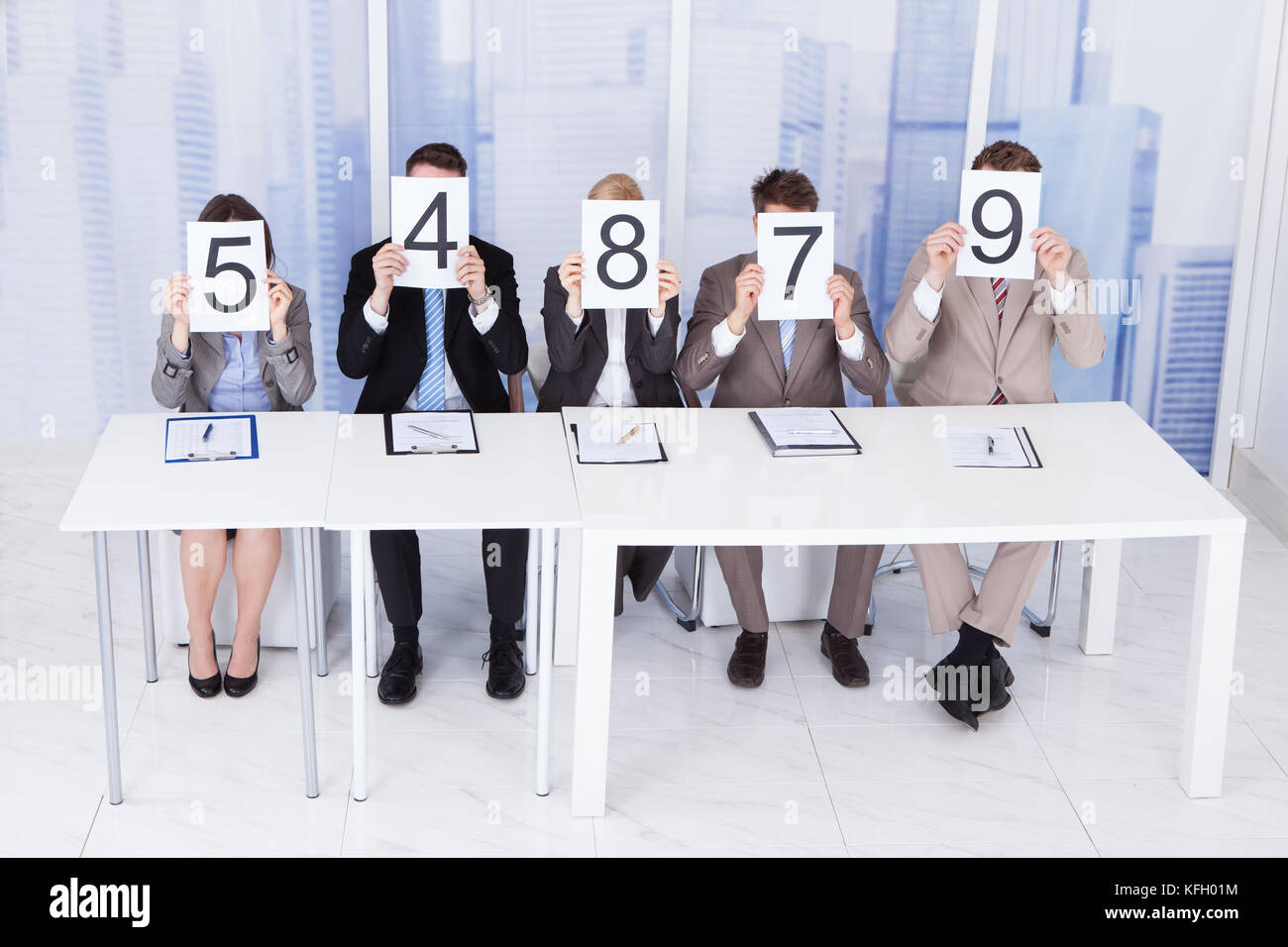 Portrait of confident business people showing score cards Stock Photo