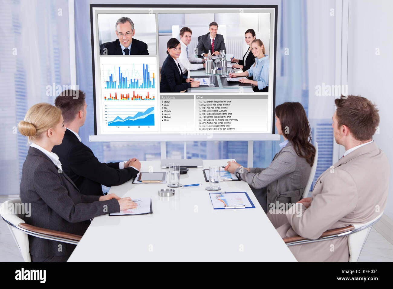 Group of business people attending video conference at table in office Stock Photo