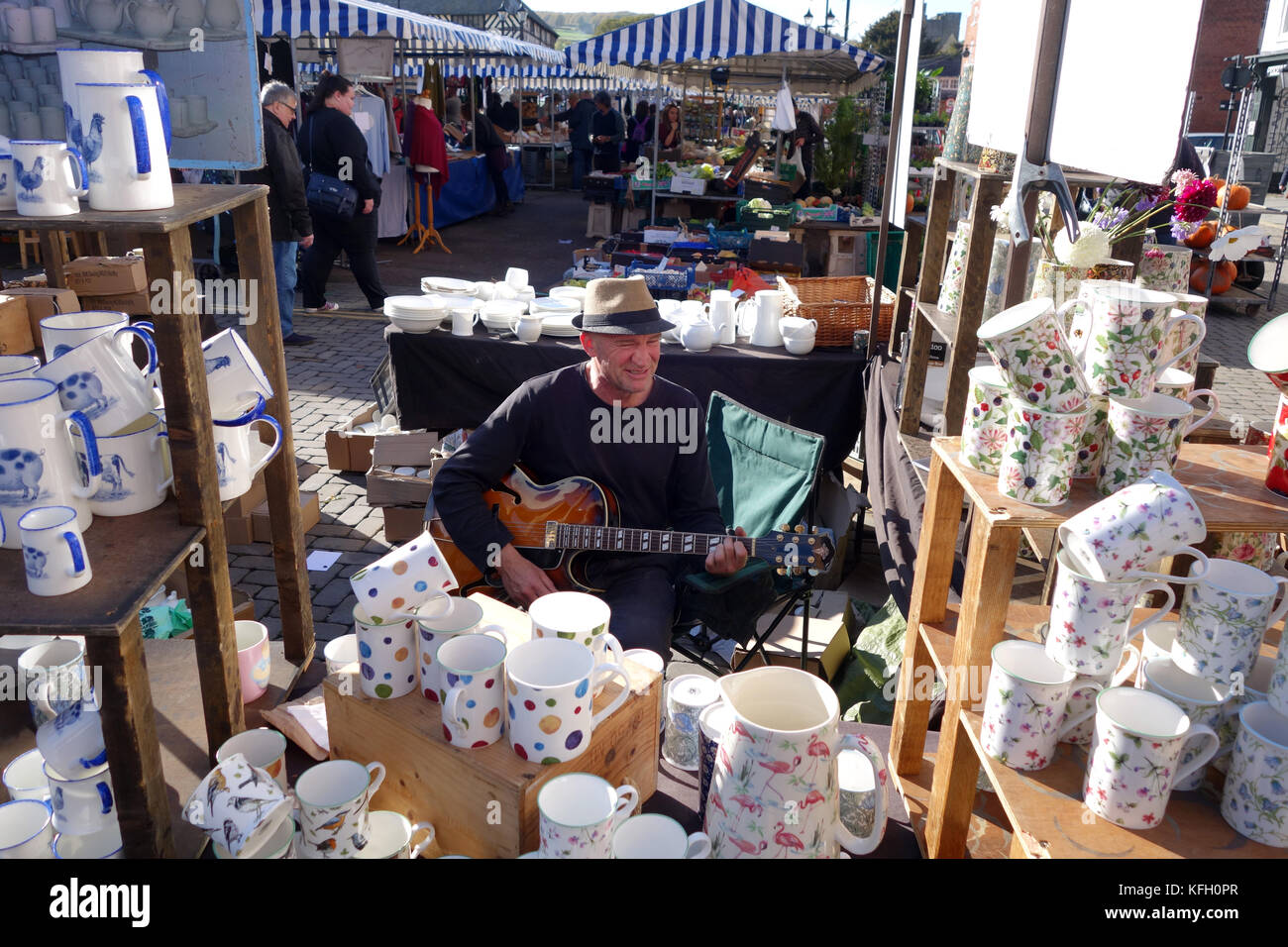 Market stallholder playing guitar at Ludlow Market in Shropshire Uk Stock Photo
