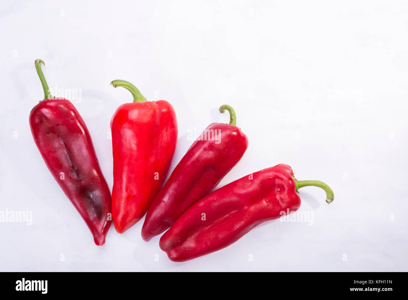 Four red peppers as a vegetable on white background Stock Photo - Alamy