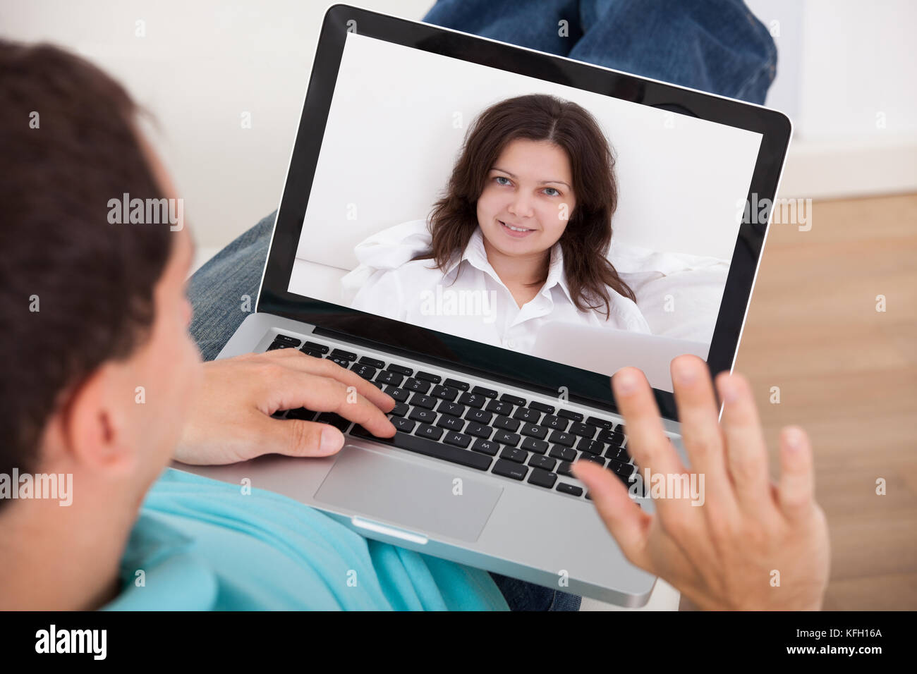 Man video conferencing with woman on laptop at home Stock Photo