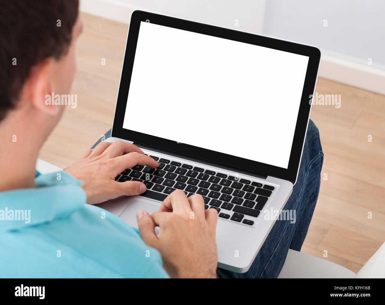 Mid adult man using laptop at home Stock Photo