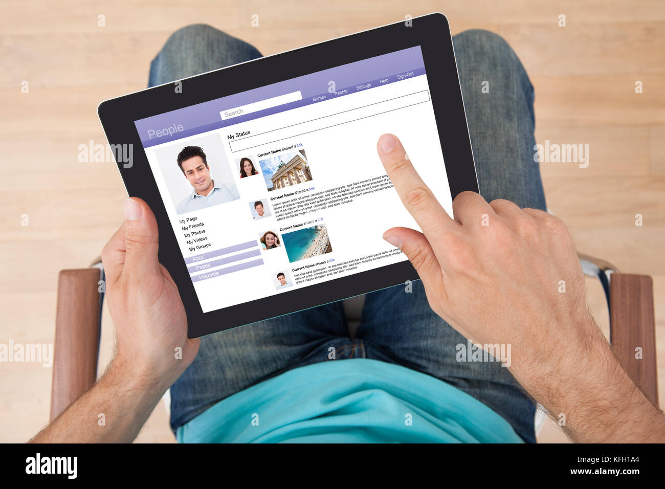 Directly above shot of man surfing on social site using digital tablet at home Stock Photo