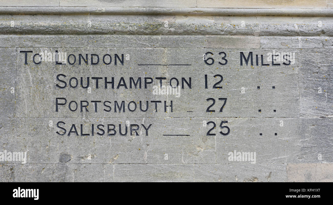 Distances to London, Southampton, Portsmouth and Salisbury carved into the stone wall of the Guildhall, Winchester. Winchester, Hampshire, UK Stock Photo