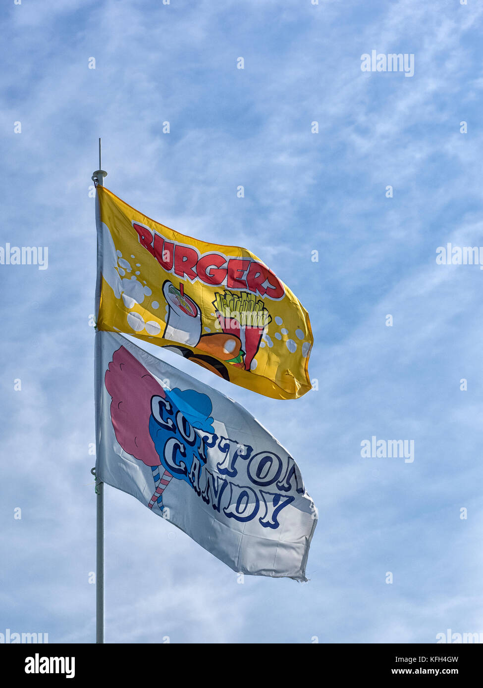 SOUTHEND-ON-SEA, ESSEX, UK - AUGUST 28, 2017:   Advertising Flags flying above beachfront kiosk selling burgers and cotton candy Stock Photo