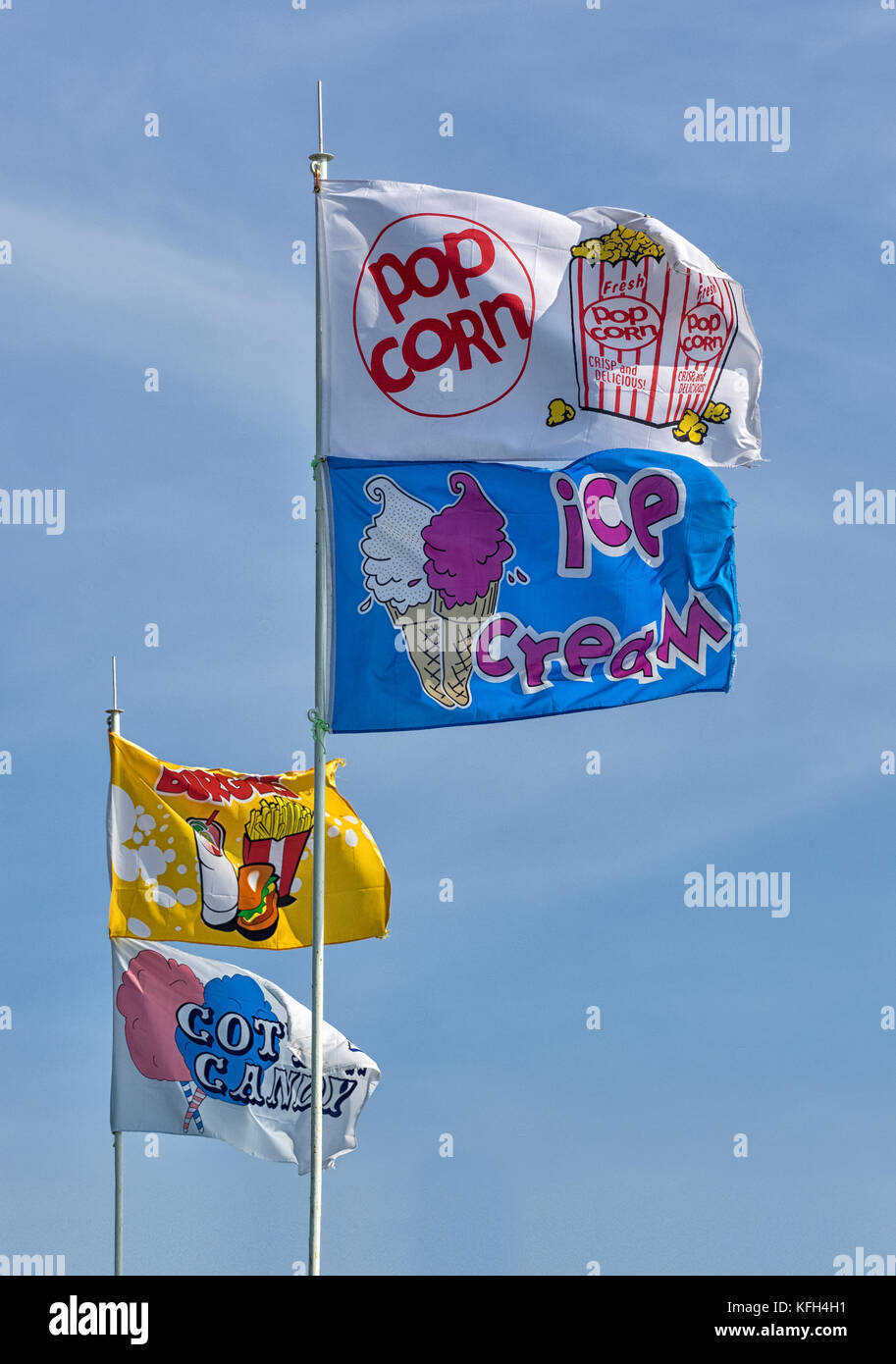 SOUTHEND-ON-SEA, ESSEX, UK - AUGUST 28, 2017:  Advertising Flags flying above beachfront shop selling Ice Cream, Popcorn, Cotton Candy (Candy Floss) a Stock Photo